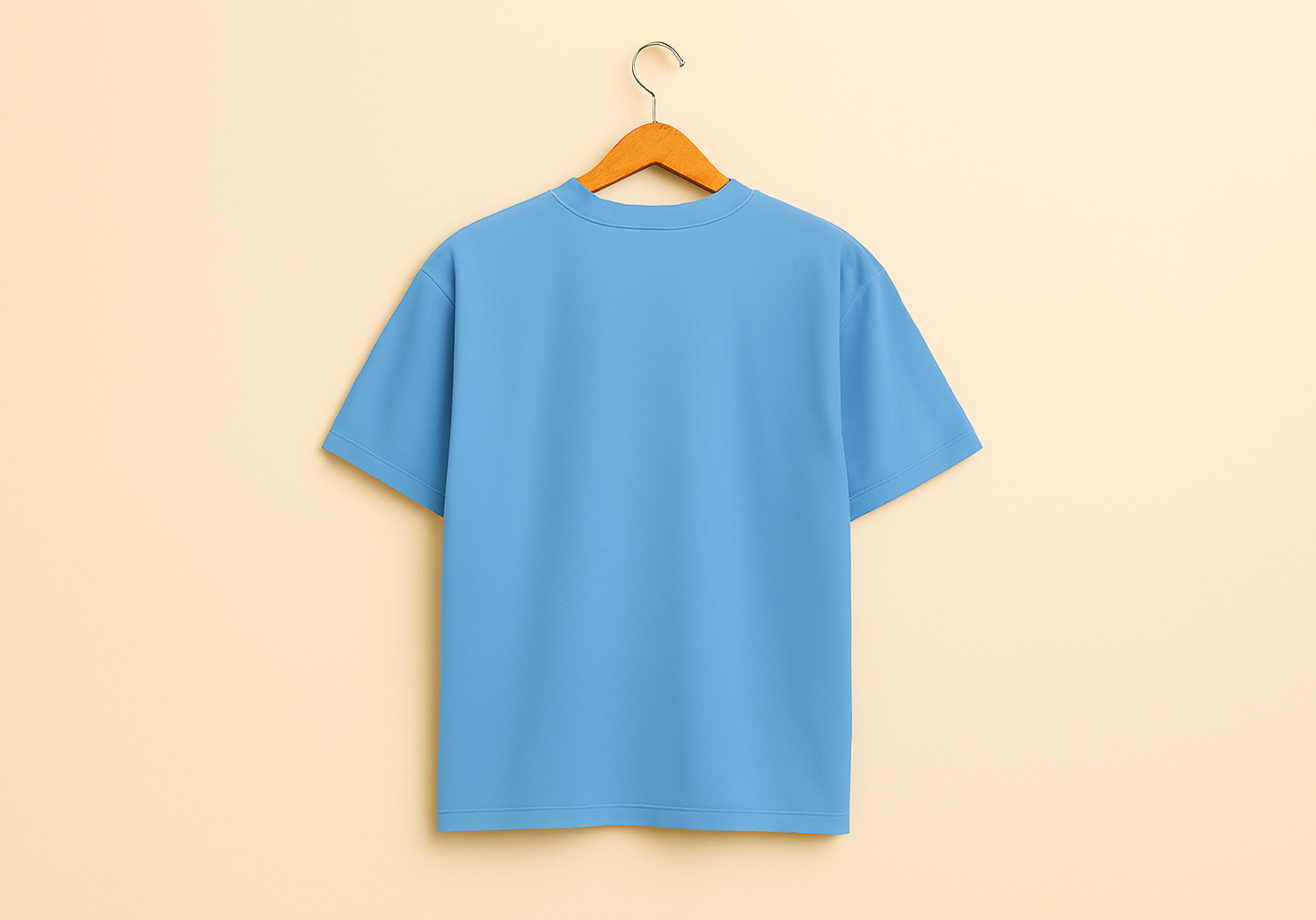 Blue t-shirt on a wooden hanger against a beige background