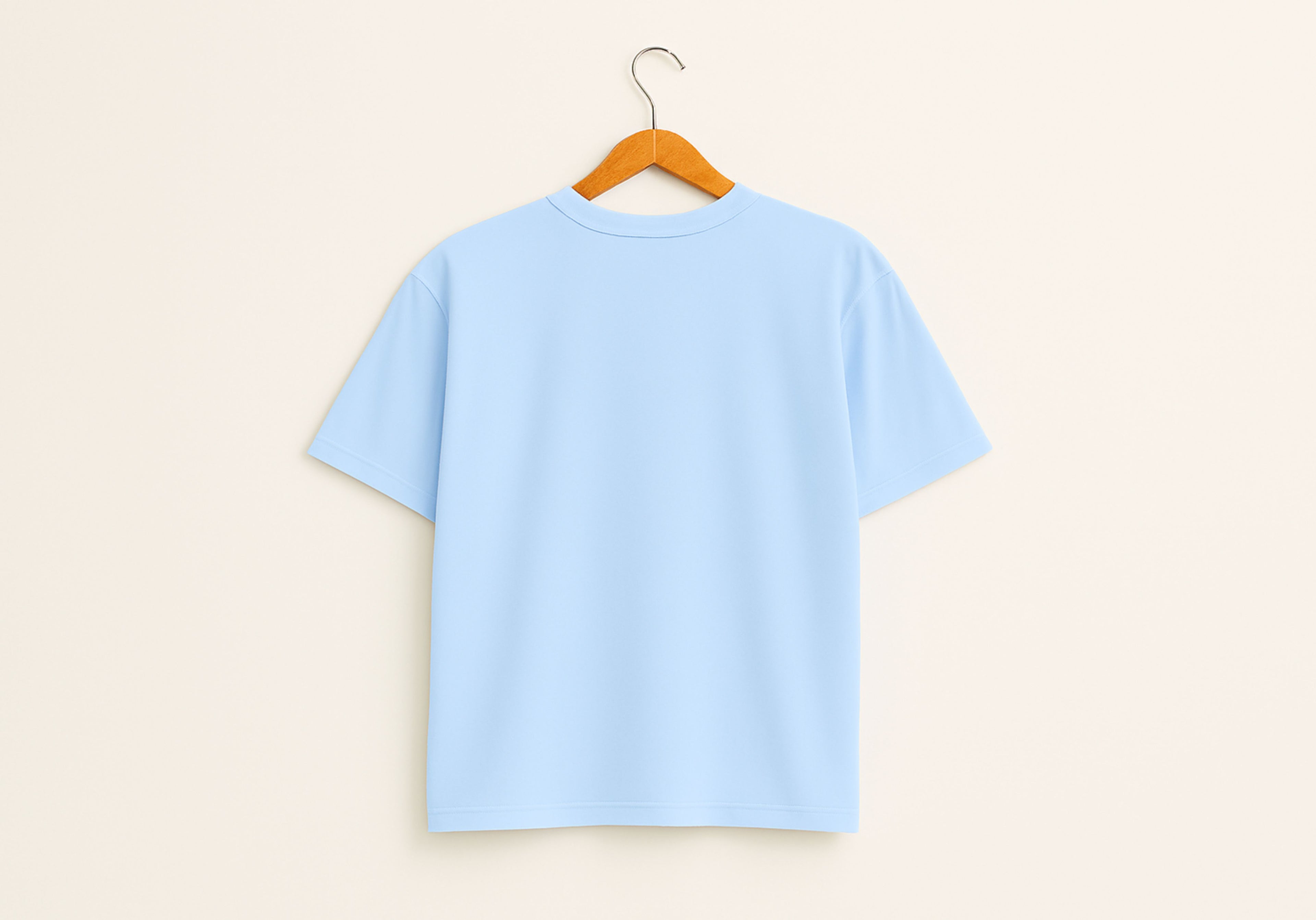 Light blue t-shirt on a wooden hanger against a light beige background