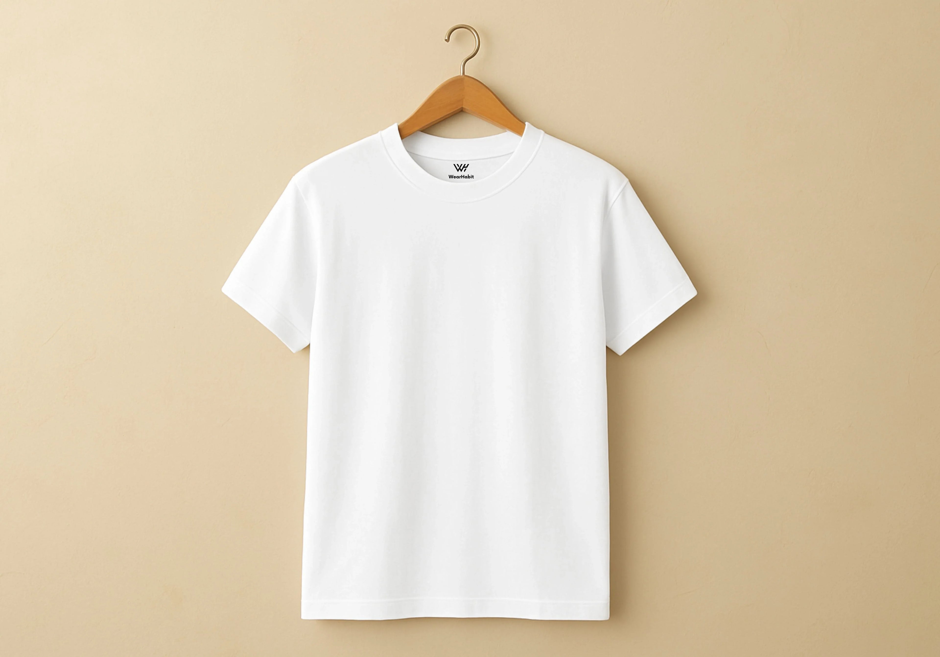 White t-shirt on a wooden hanger against a beige background