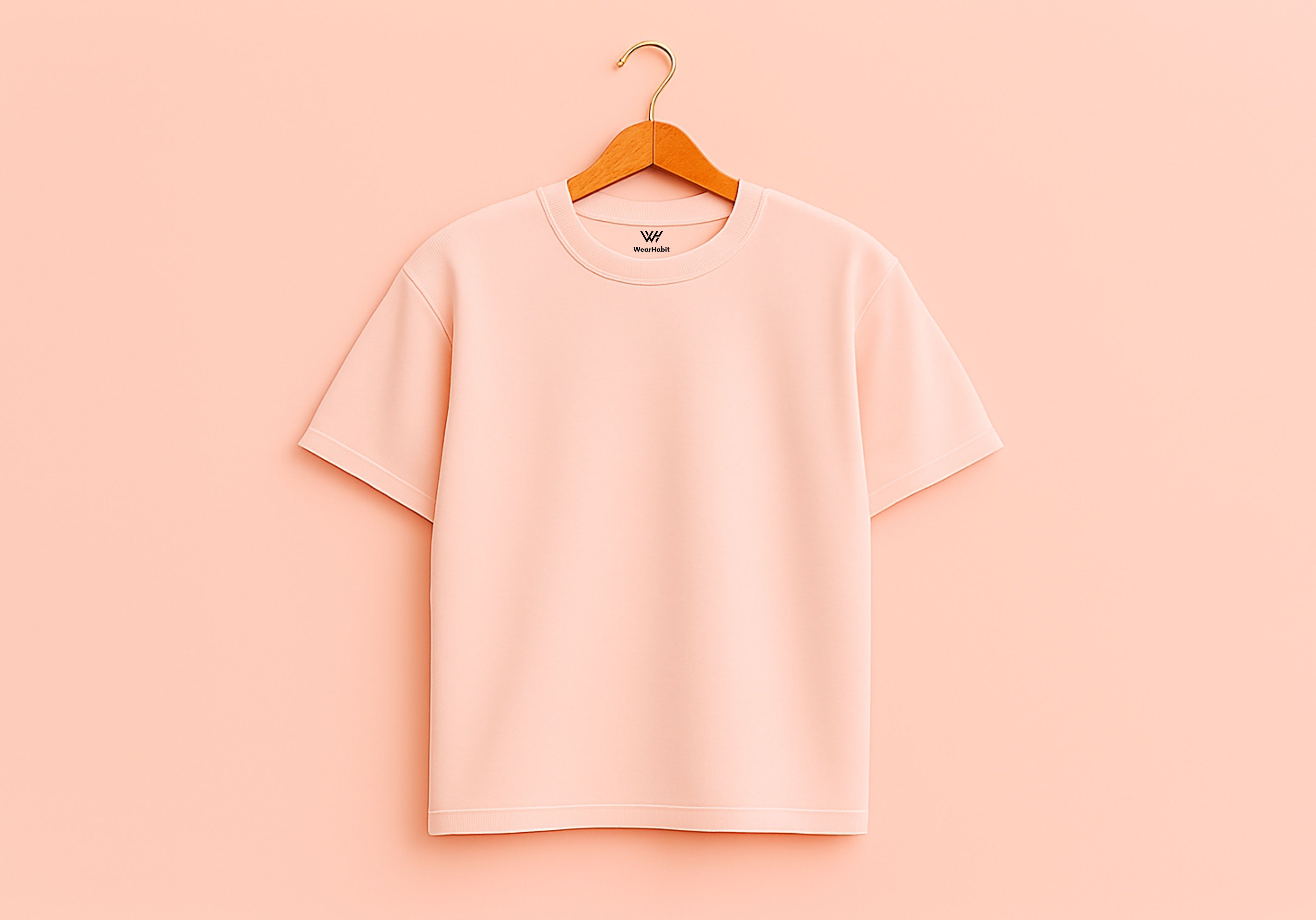 Pink t-shirt on a wooden hanger against a pink background