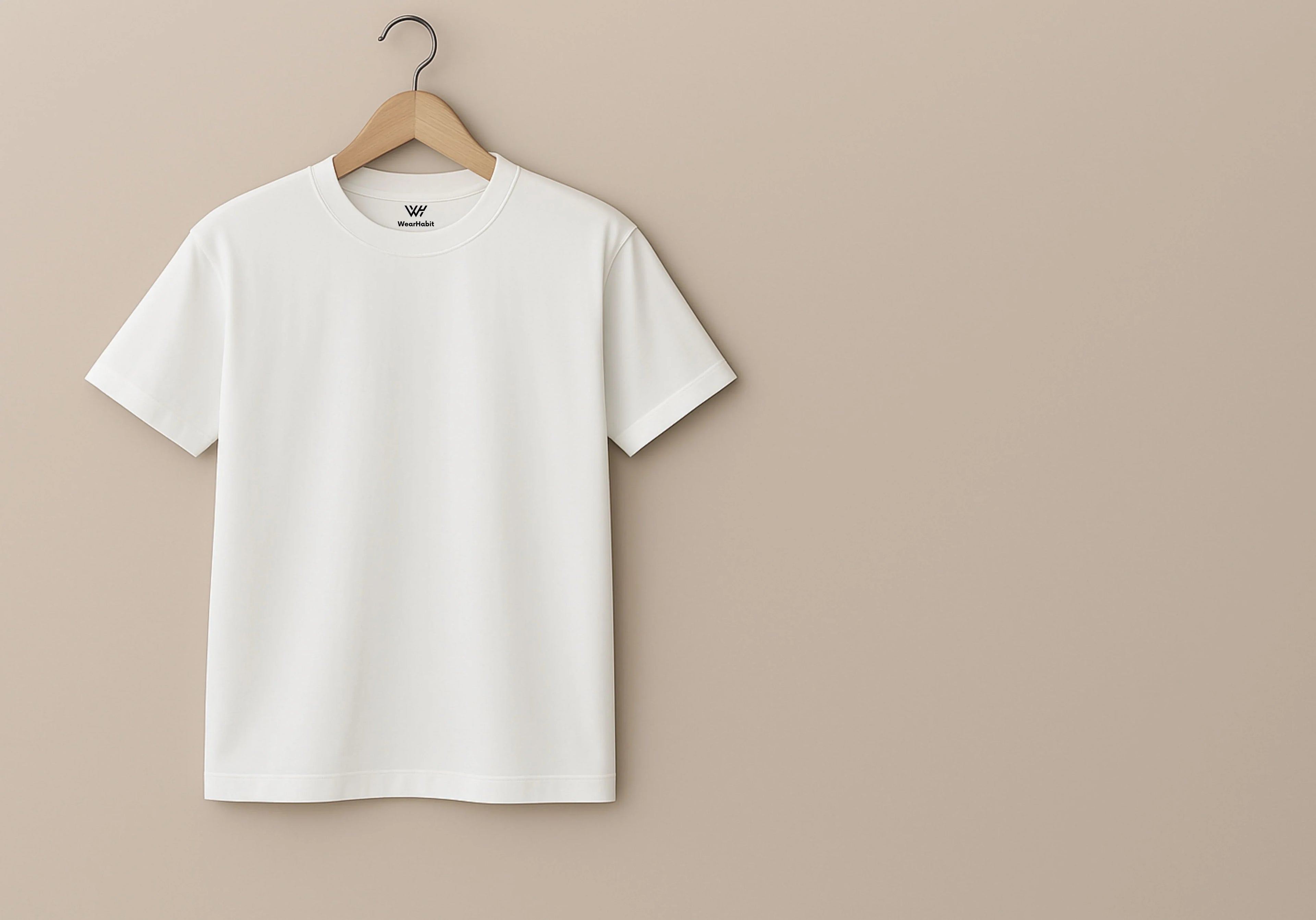 White t-shirt on a wooden hanger against a beige background