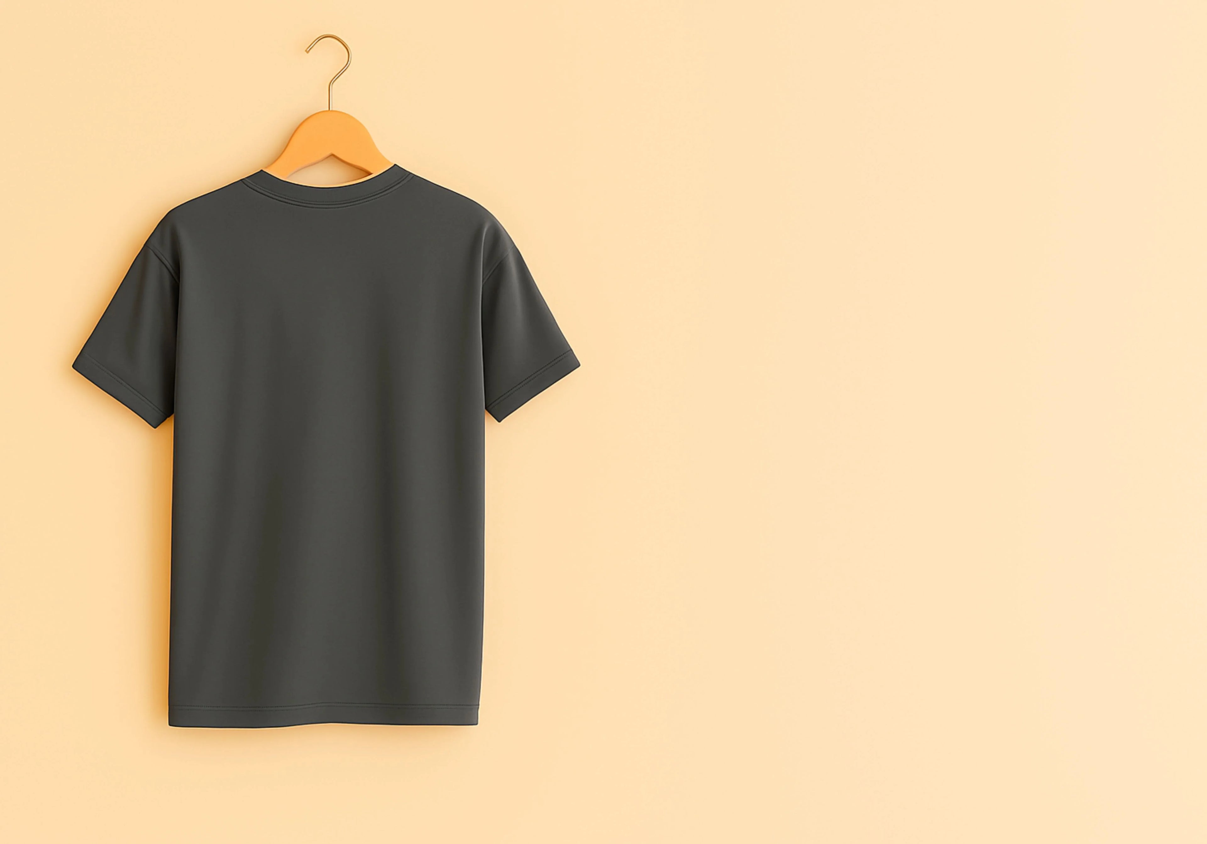 Black t-shirt on a wooden hanger against a beige background