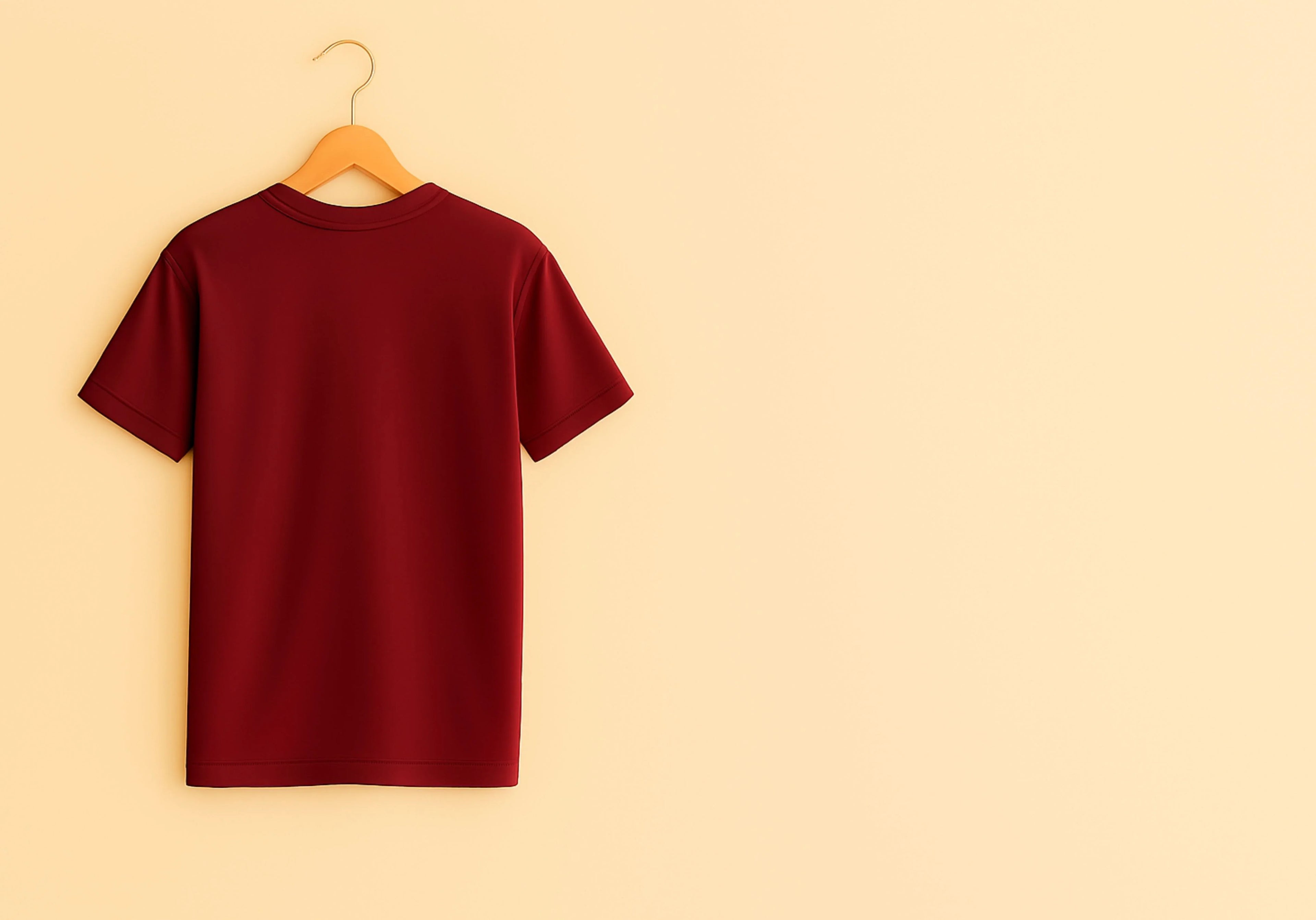 Maroon t-shirt on a wooden hanger against a beige background
