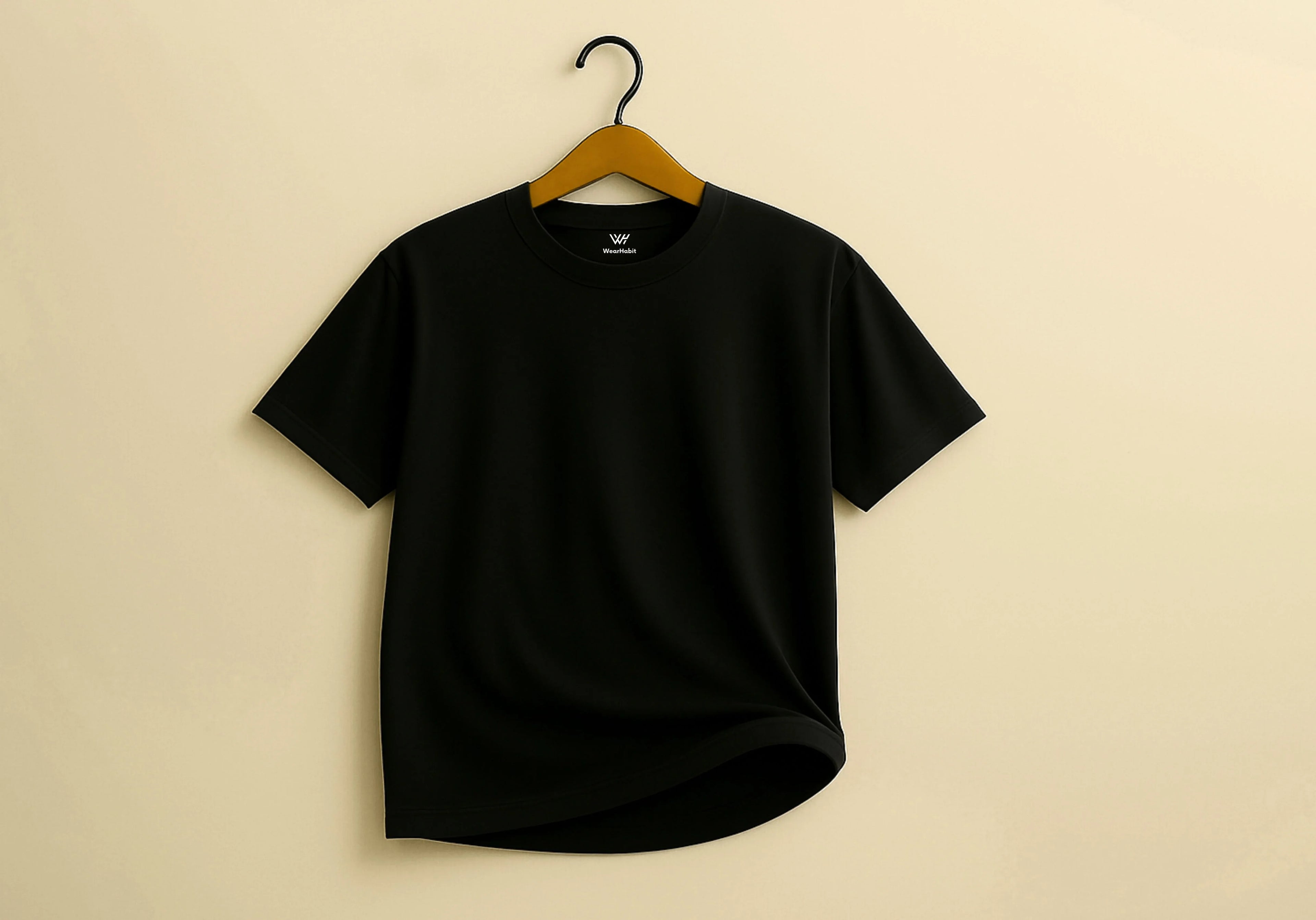 Black t-shirt on a hanger against a beige background