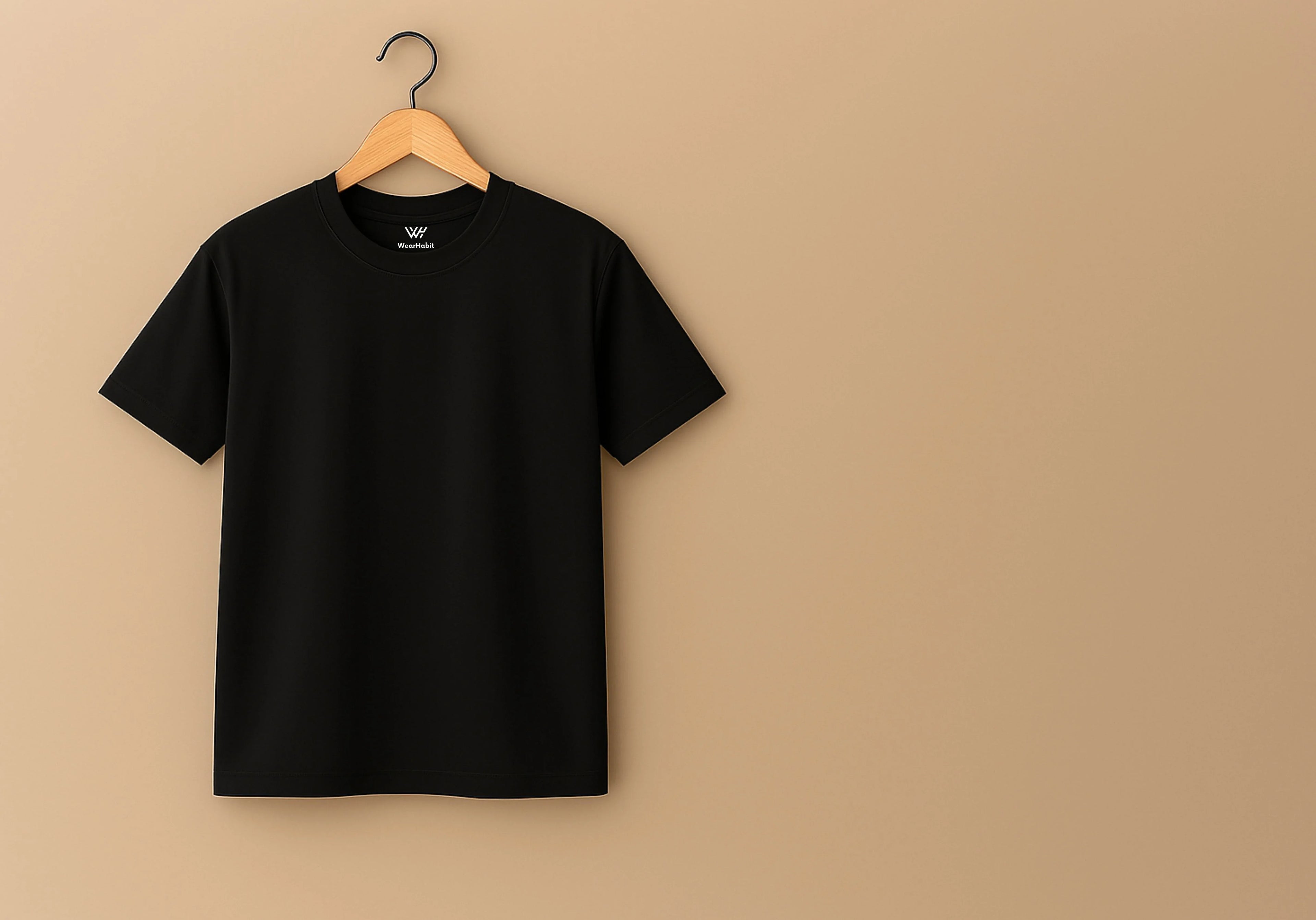 Black t-shirt on a wooden hanger against a beige background