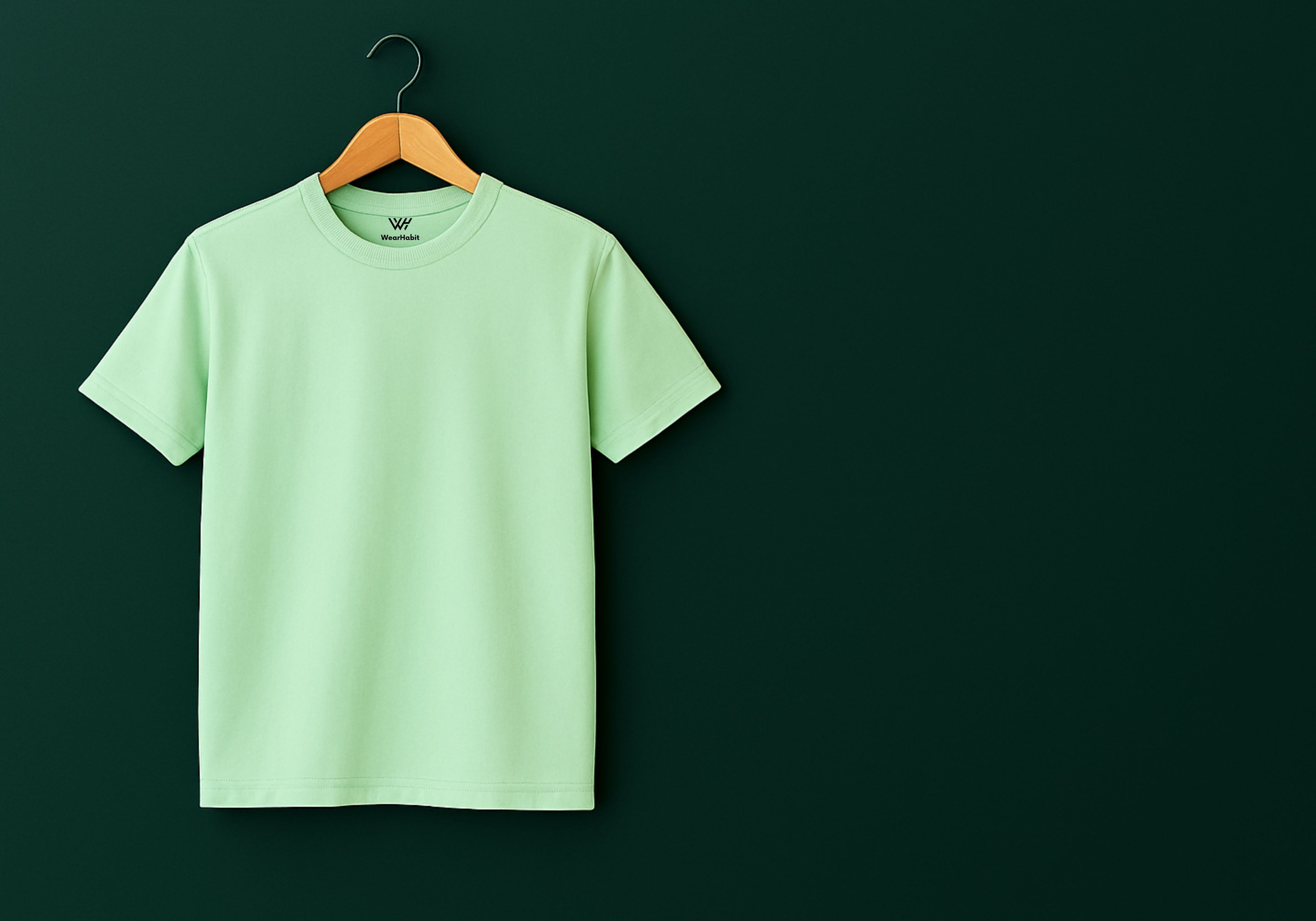 Light green t-shirt on a wooden hanger against a dark green background