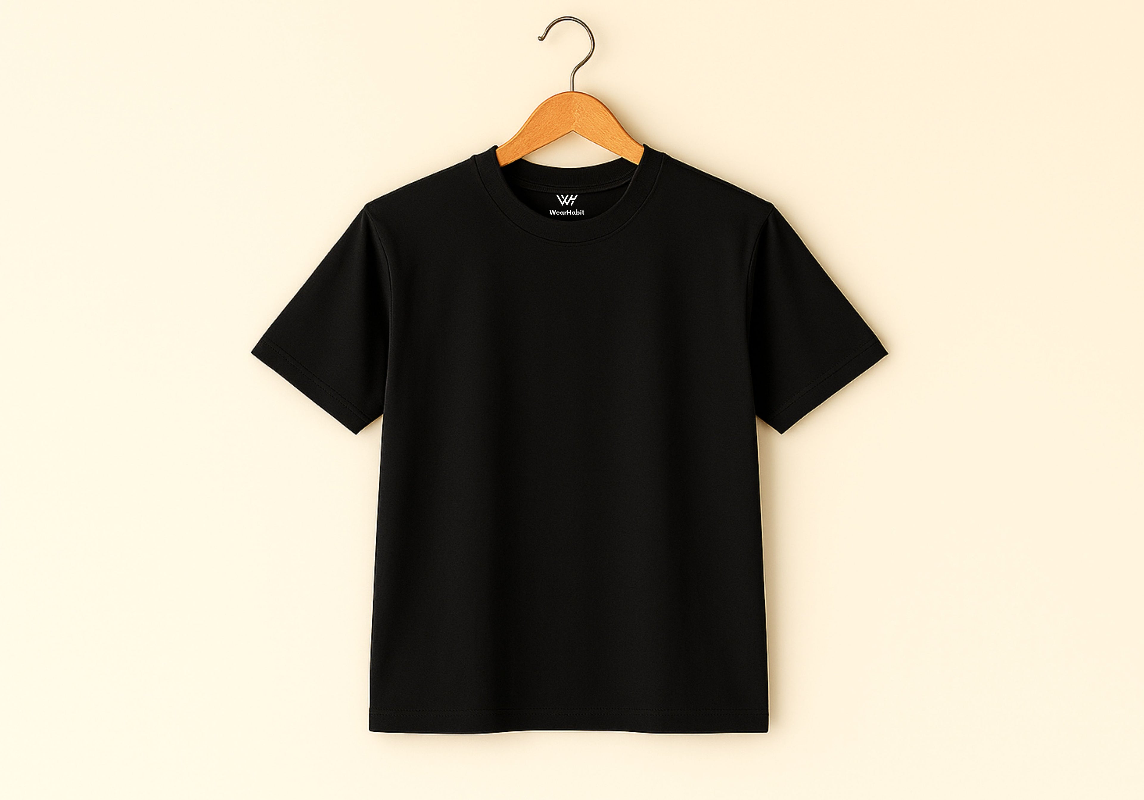 Black t-shirt on a wooden hanger against a beige background
