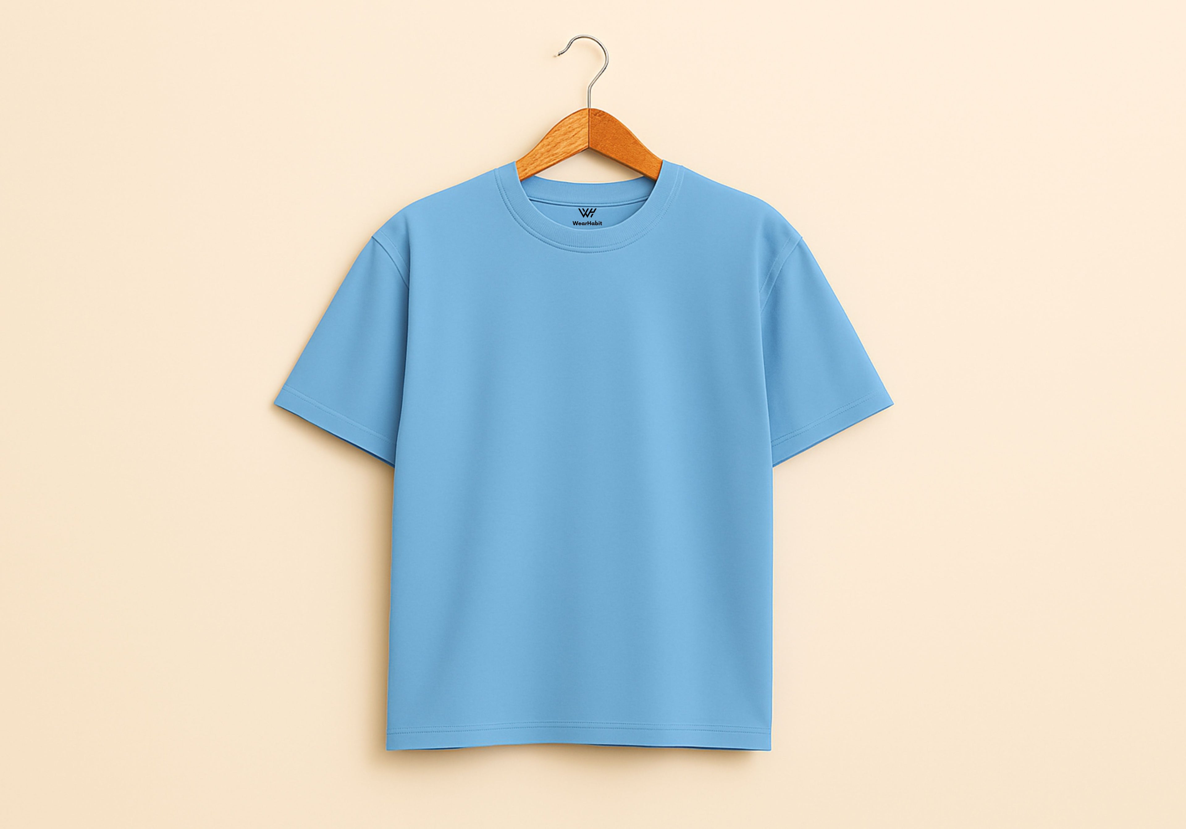 Blue t-shirt on a wooden hanger against a beige background